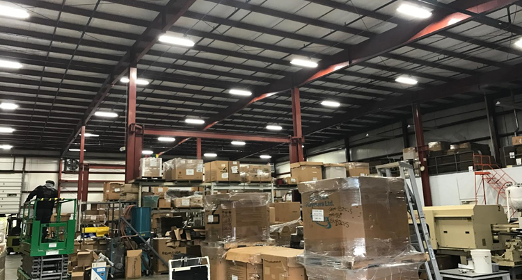 lighting retrofit job for warehouse, a warehouse lighting retrofit job, picture of a warehouse with a bunch of boxes piled up that has a lighting retrofit job
